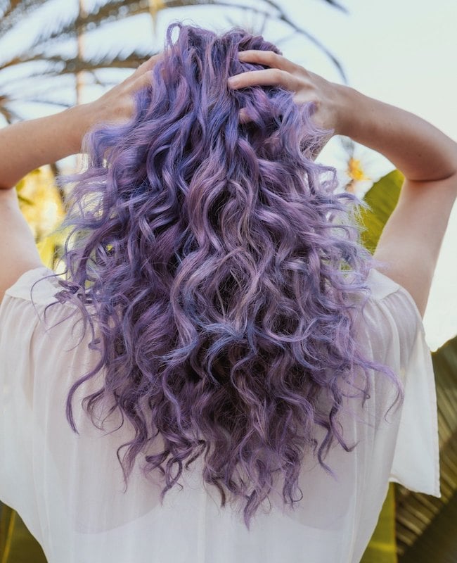 Woman with curly hair and purple hair color